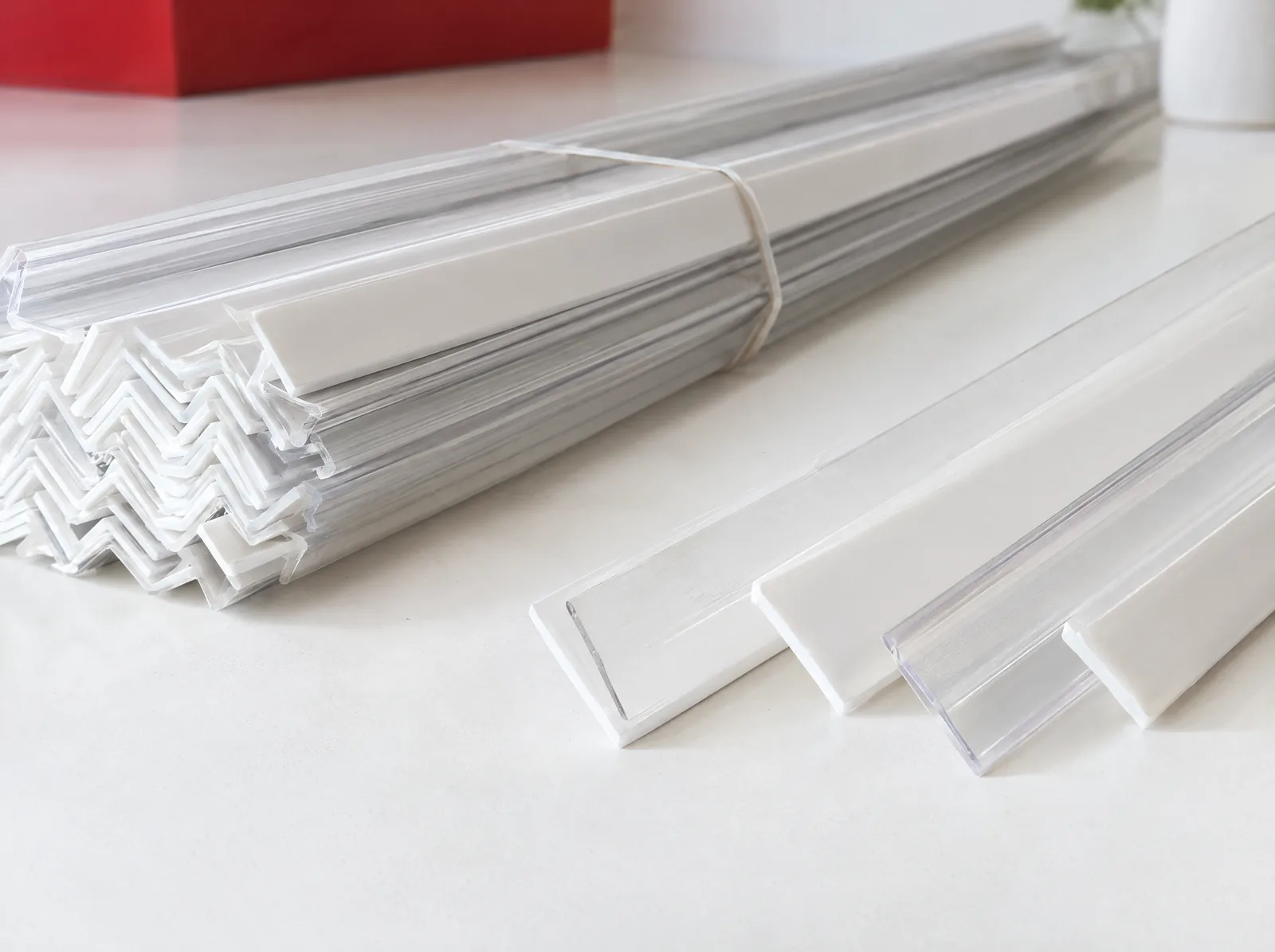 White and clear plastic L-shaped corner bracket profiles